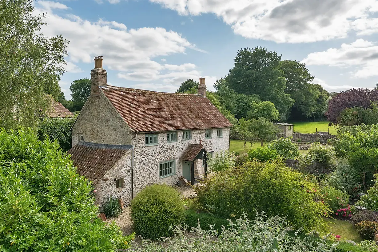 The grounds at Lakehayes, one acre including a stream, paddock and the Grade II listed Tudor farmhouse